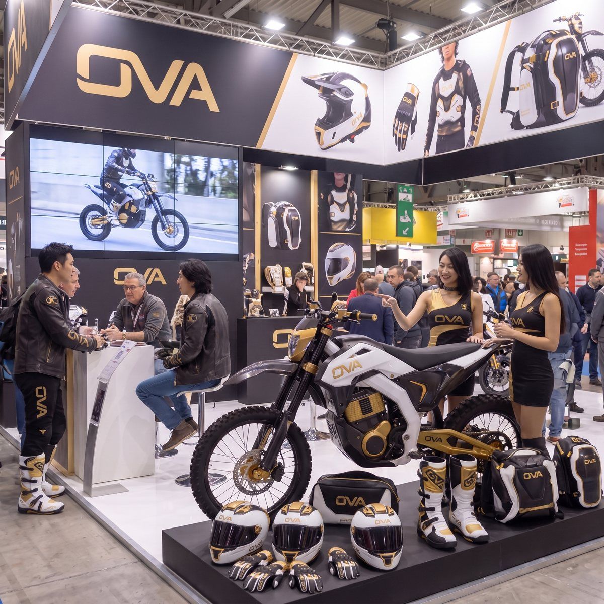 OVAブースでMXバイクを紹介するスタッフと来場者