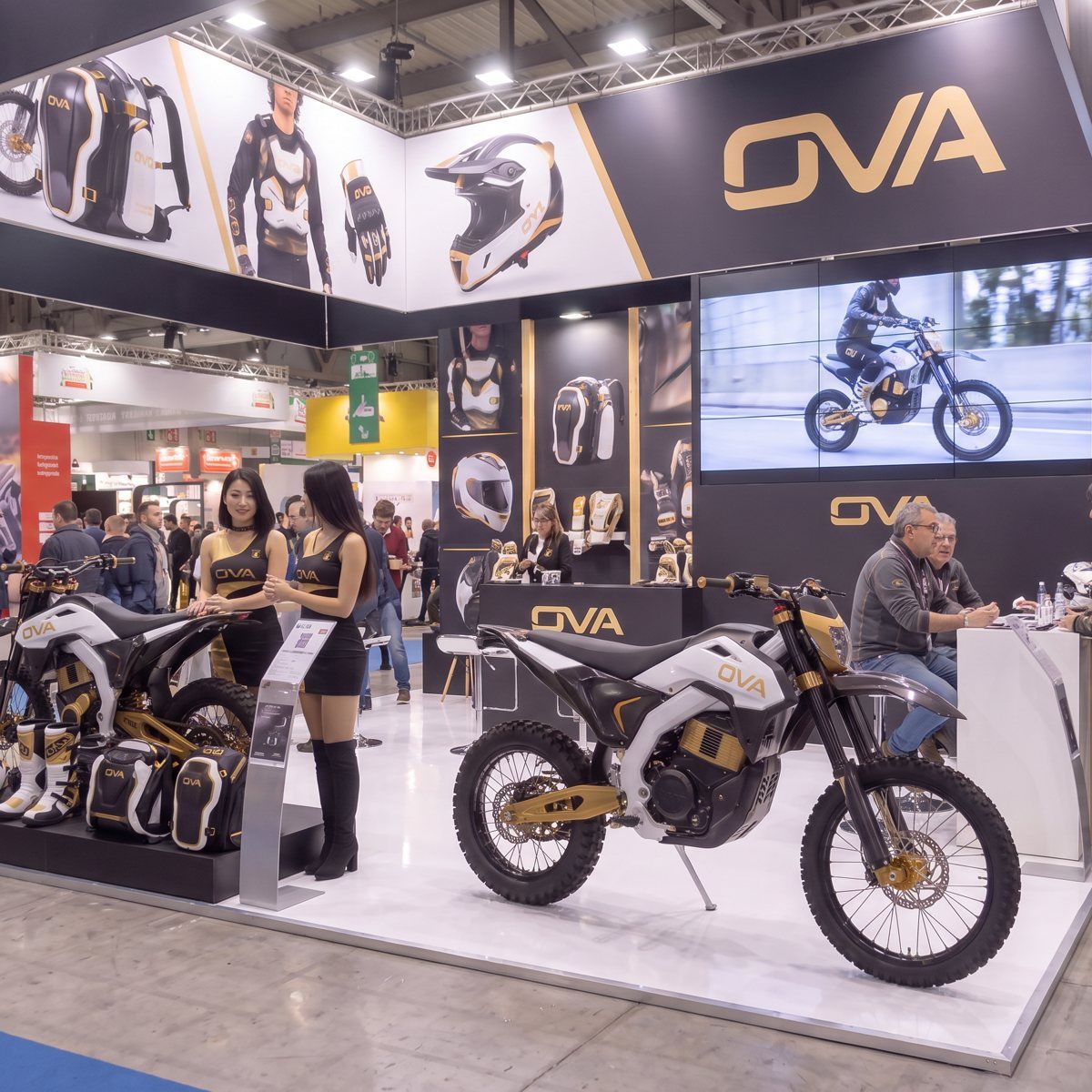 OVAブースの全景、2台のMXバイクと展示ギア